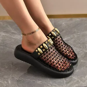 Nahaufnahme schwarzer Mesh-Plateau-Pantoletten mit Goldnieten und atmungsaktivem Hohlraum-Design