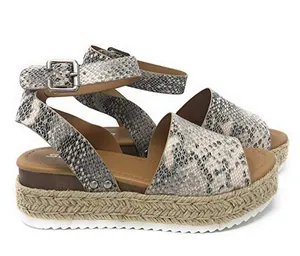 Primer plano de sandalias de plataforma tipo alpargata para mujer con estampado de serpiente