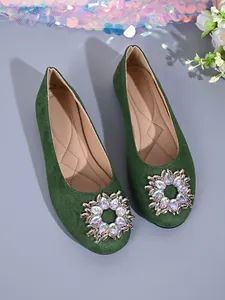 Nahaufnahme des grünen Wildleders und der Kristallschnalle dieser eleganten Ballerinas