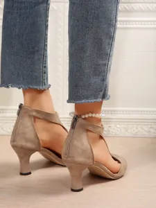 Detail of khaki suede high heel sandals with pearl anklet and back zipper closure.