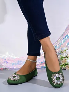 Detailansicht eleganter grüner Ballerinas mit einer großen funkelnden Strass-Schnalle