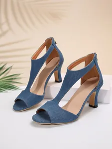 Detailed view of blue denim peep-toe sandals with elegant hollow-out design.