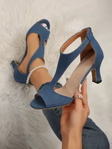Close-up of blue denim peep-toe sandals with cutout design and high stiletto heels