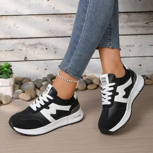 Gros plan de baskets compensées pour femmes en noir et blanc avec semelles épaisses