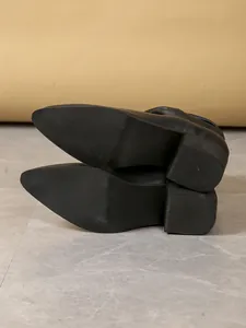 Close-up of the non-slip textured sole and block heel on black women's boots
