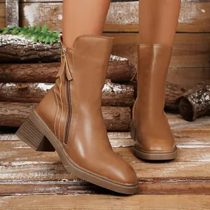 Detailed macro view of vintage brown leather Chelsea boots with chunky heels.
