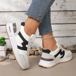 Vue latérale détaillée des baskets plateforme blanches et noires à semelle épaisse.
