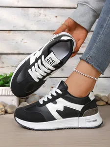 Vue détaillée de baskets compensées pour femmes en noir et blanc avec semelles épaisses.