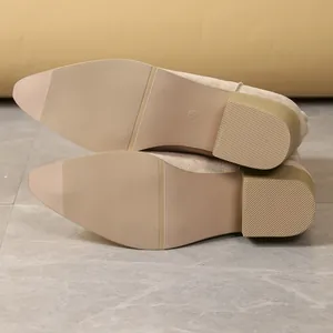 Detail view of anti-slip soles of brown suede Martin boots with thick heels