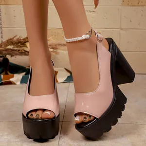 Close-up of pink patent leather peep-toe sandals with chunky black platform heels.