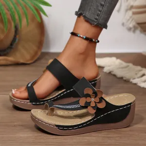 Women's black wedge sandals with elegant flower detail and white contrast stitching