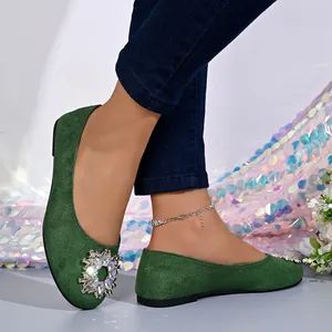 Ballerines élégantes en velours vert avec grande boucle en strass sur bout rond.