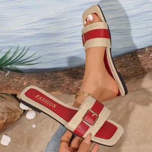 Detailansicht von gewebten flachen Sandalen mit rotem Schnallenriemen und Karree