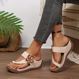 Detailed side view of stylish pink wedge sandals with flower decoration worn on feet
