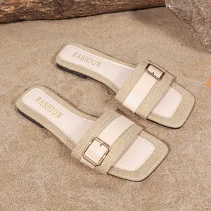 Detailansicht beige flache Pantoletten mit Webstruktur und goldener Schnalle