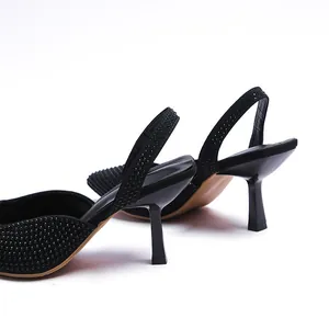 Close-up detail of black rhinestone slingback sandals featuring a sleek stiletto heel