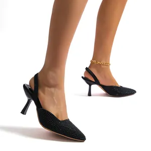 Elegant black rhinestone pointed toe slingback heels on a model with high heels.
