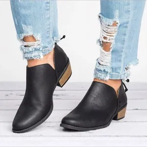 Detail van zwarte schoenen met spitse neus, lage blokhak, V-uitsnijding en ritssluiting