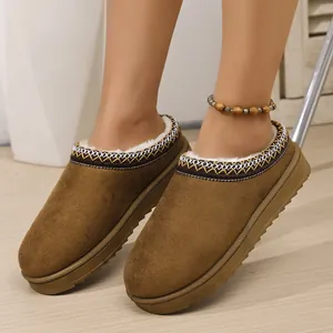Detailed view of women's brown suede slippers with thick soles and warm faux fur lining