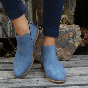 Detailed view of blue faux suede pointed-toe ankle boots featuring a stylish side cut-out