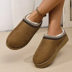 Detail view of brown suede platform slippers with warm faux fur lining and ethnic trim