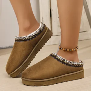 Close-up of brown suede snow boot slippers with thick soles and cozy faux fur lining