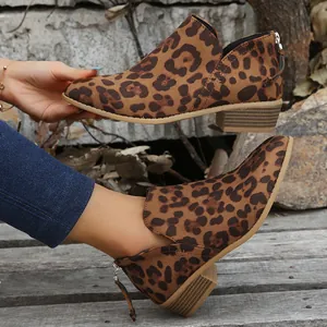 Close-up of leopard print ankle boots with pointed toe and back zipper tassel detail.