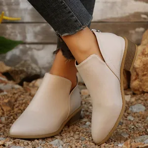 Gedetailleerd zicht op elegante beige enkellaarsjes met puntige neus en lage blokhak