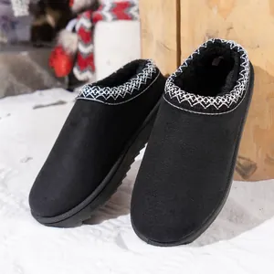 Detail view of black suede warm slippers with decorative embroidery and plush fur lining