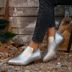 Gedetailleerde weergave van zilveren metallic enkellaarsjes met een lage blokhak