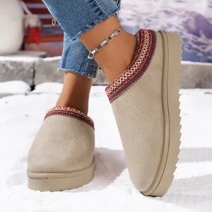 Close-up detail of beige suede platform snow slippers with colorful embroidered collar