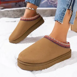 Close-up of brown suede platform slippers with decorative woven trim on model's feet