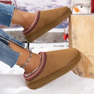 Cozy brown suede fur-lined backless mule snow slippers displayed on a scenic winter snow background