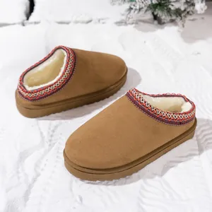 Close-up of warm brown platform snow boot slippers with ethnic embroidered collar.