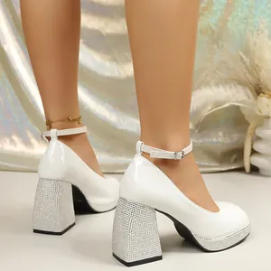 Detailed view of white patent leather platform Mary Jane pumps with sparkling rhinestone heels