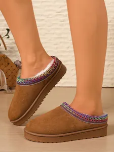 Close-up showing the colorful embroidered trim and warm fuzzy lining on these brown slippers