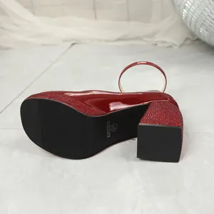 Close-up of red rhinestone platform and block heel on patent leather Mary Jane shoes