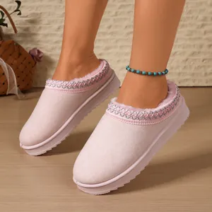 Detail view of pink platform snow boot slippers with plush lining and woven trim