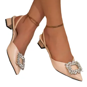 Elegant nude beige slingback pumps featuring a sparkling rhinestone buckle and pointed toe design
