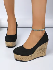 Vista detallada de zapatos de cuña negros con plataforma de corcho en el modelo real