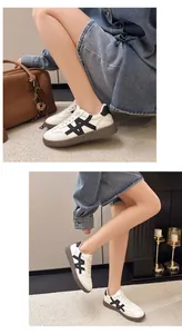 Side view of white platform sneakers with black pattern and thick brown soles