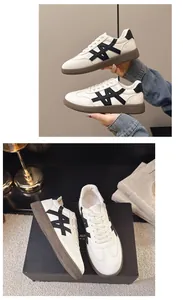 Detailed view of women's white leather sneakers with black accents and brown soles