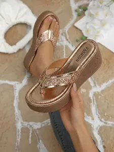 Macro view of metallic rose gold platform wedge thong sandals with glitter straps