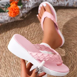 Detailed view of pink wedge flip-flops featuring a stylish braided strap for summer