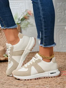 Primo piano di scarpe sportive chunky beige da donna con suola spessa 3,5 cm