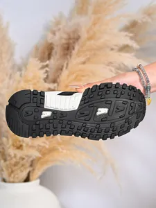 Dettaglio della resistente suola in gomma bianca e nera di una sneaker da donna.