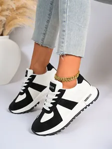 Vista dettagliata di eleganti sneakers bicolore bianco e nero indossate con una cavigliera