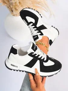 Primo piano di sneakers da donna in bianco e nero con suola spessa e design patchwork
