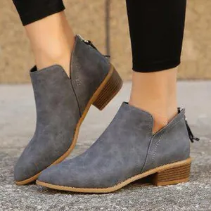 Close-up of grey suede pointed toe ankle boots with V-cut and low block heel.