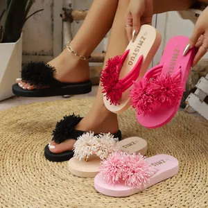 Selección de chanclas con plataforma de colores y grandes adornos de flores deshilachadas